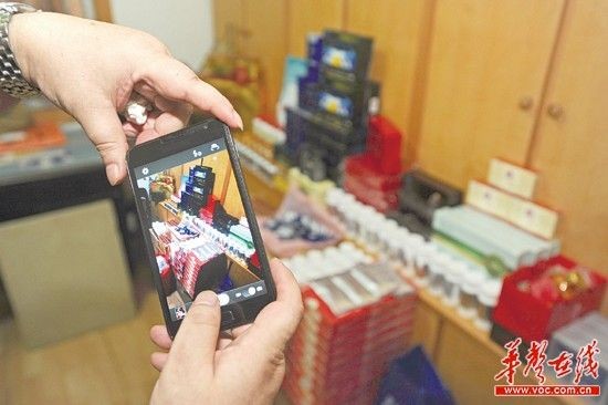 7月18日，徐廷柱的儿子正用手机拍摄老人生前购买的保健品。 记者 唐俊 实习生 罗广林 摄